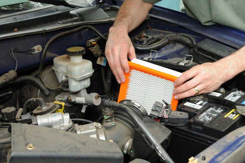 A mechanic changing the car air filter.